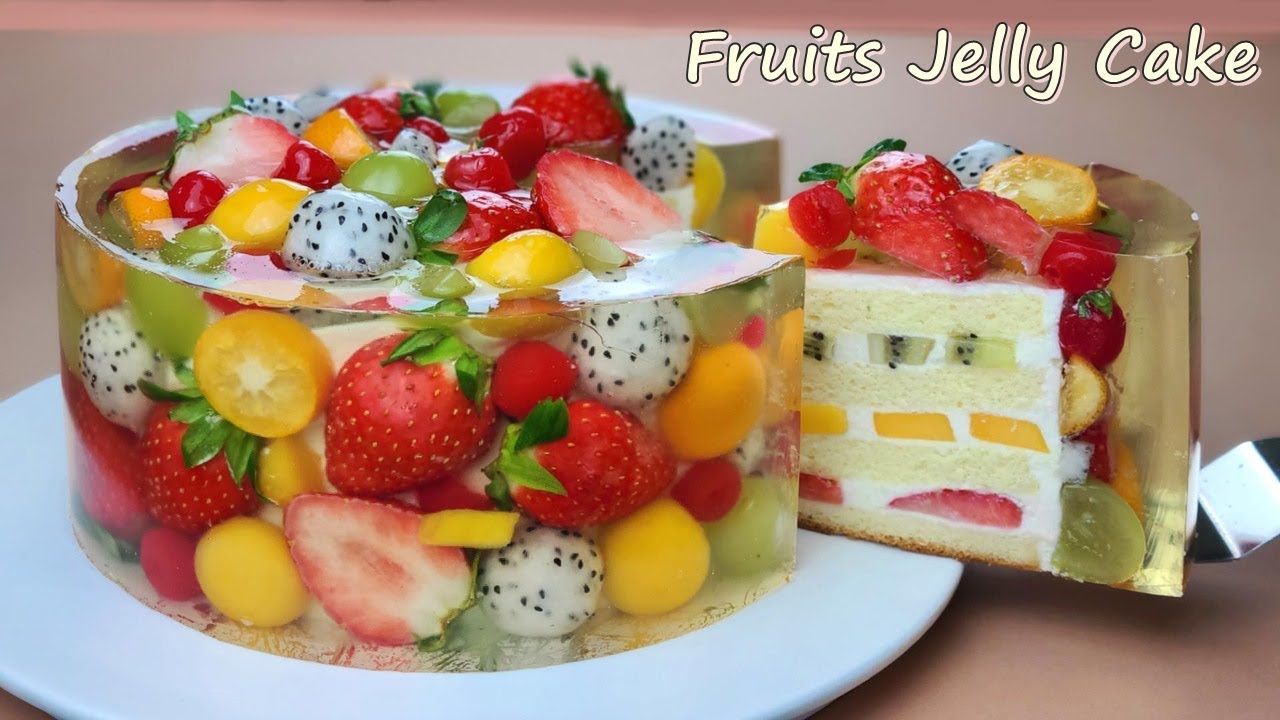 Photograph of encapsulated jelly cake made with pieces of strawberry, kiwi,  mango and grapes, the cake is seen from the front with a photo studio  background on Craiyon
